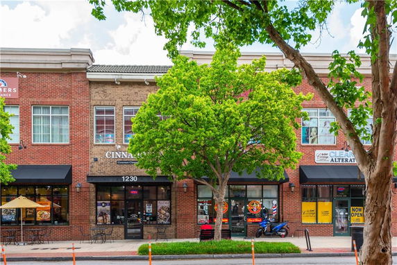 Front view of a brick commercial building with large windows and storefronts.