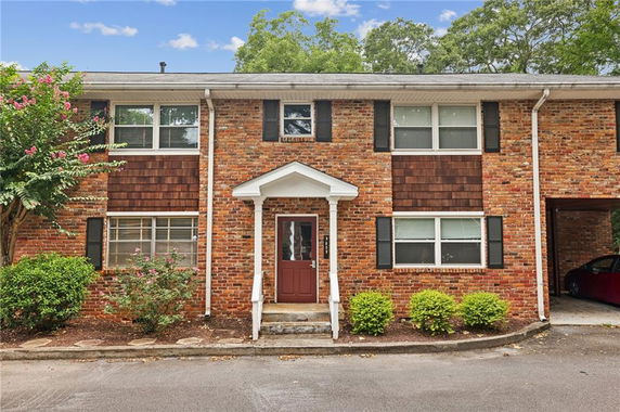 Front view of a two-story brick house with a covered entryway.