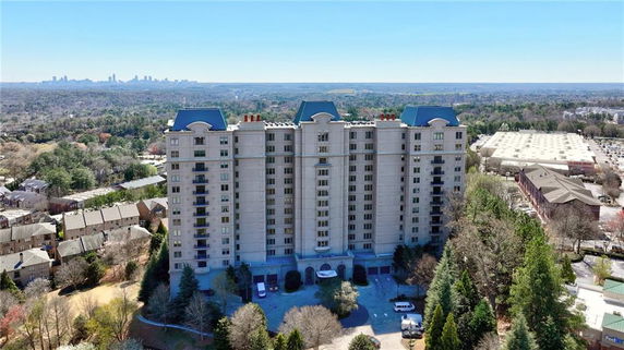 Front view of a multi-story building with a unique rooftop design.