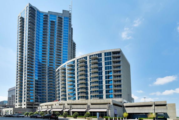 Front view of a modern high-rise building with glass windows and balconies.