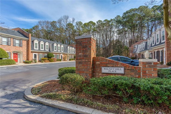 Front view of townhouse complex with red brick facades and dormer windows.