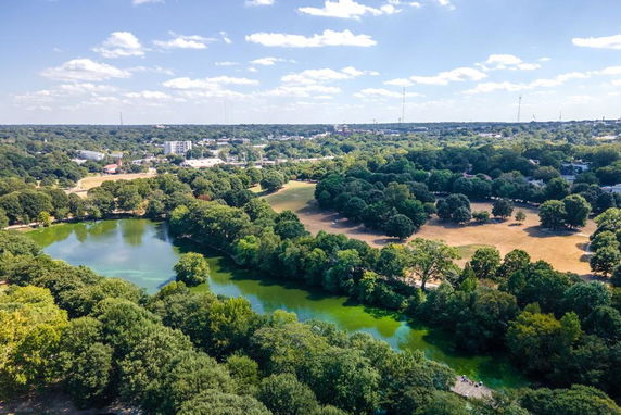 Wide angle view of a landscape with trees and a body of water.