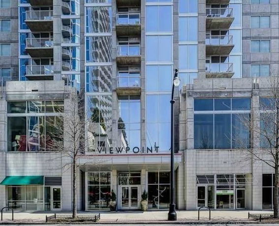 Front view of a multi-story building with balconies and glass facade.