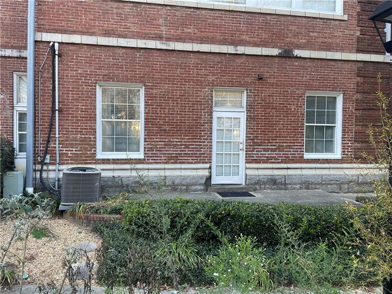 Exterior view of a brick building with windows and a white door.
