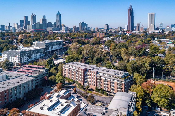 Aerial view of a city skyline with residential and commercial buildings surrounded by trees.