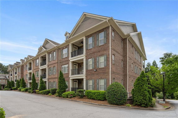 Front view of a multi-story brick apartment building with balconies.