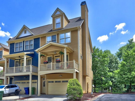 Front view of a multi-story house with a garage and balconies.