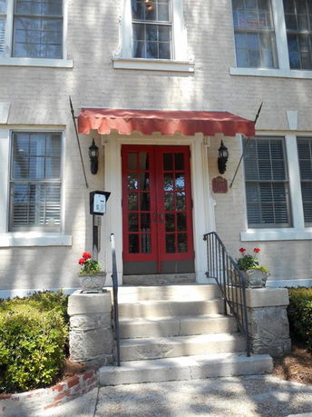 Front view of a building with a red door and canopy.
