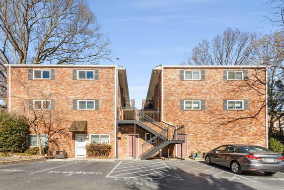 Front view of a brick apartment building with outdoor staircase.
