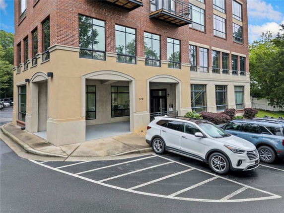 Front view of a multi-story commercial building with large windows and a parking area.