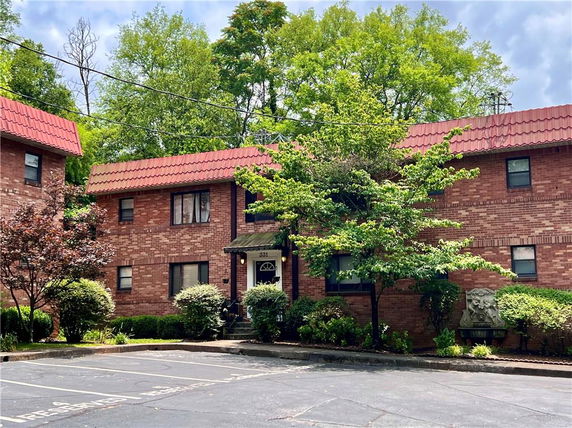 Front view of a two-story brick building with red roof tiles.