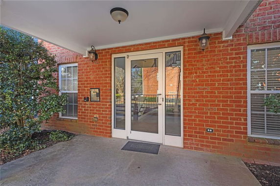 Front view of a building with a brick exterior and glass entrance door.