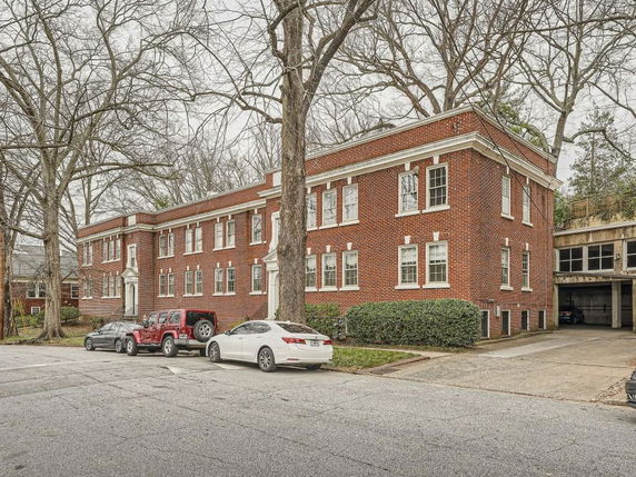 Front view of a two-story brick apartment building with multiple windows.
