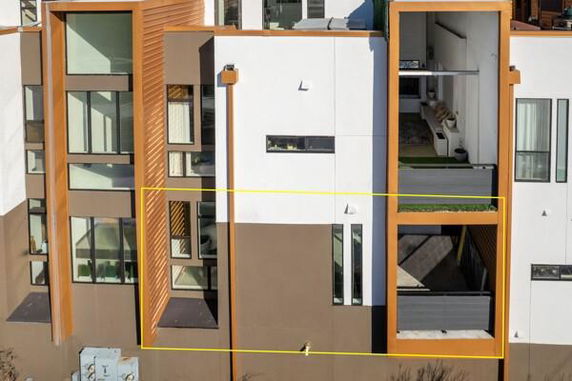 Exterior view of a modern multi-story building with large windows and distinct architectural features.