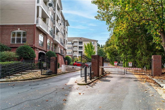 Front view of a multi-story residential building with gated entrance.