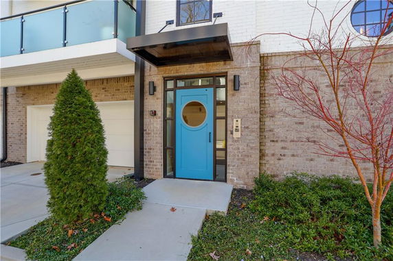 Front view of a house entrance with a blue door and attached garage.