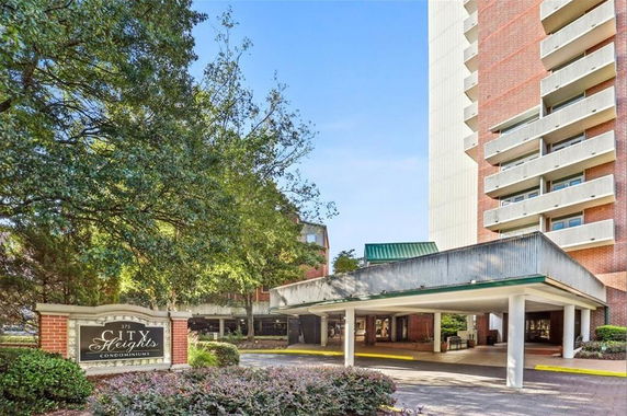 Front view of a condominium building with balconies and an entrance area.