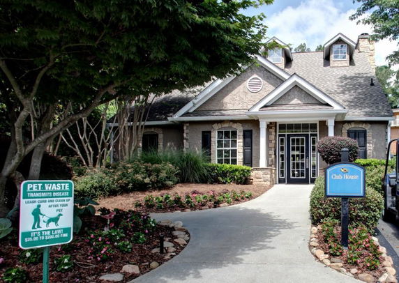Front view of a clubhouse with a gabled roof and stone accents.