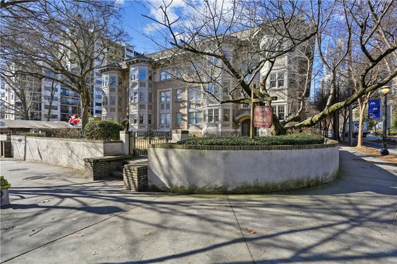 Front view of a multi-story apartment building with bay windows.
