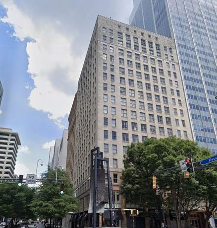 Front view of a tall, multi-story building in an urban area.