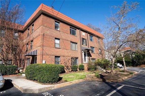 Front view of a multi-story brick building with a red-tiled roof.