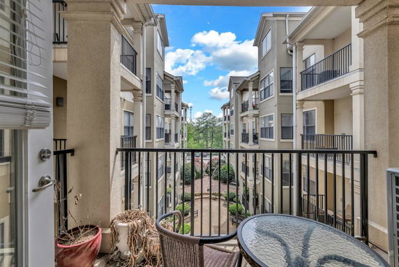 View from balcony of an apartment building showing surrounding buildings and courtyard.