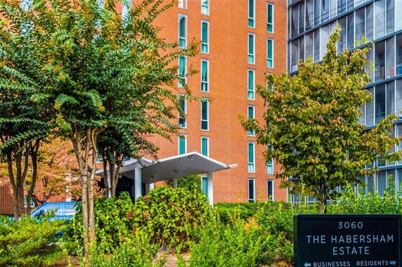 Front view of a multistory brick building with large windows and a canopy entrance.