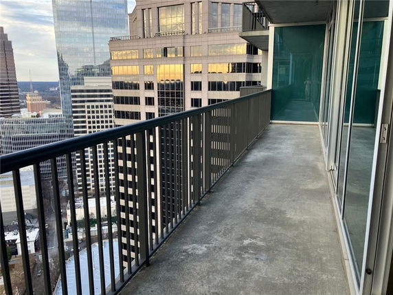 View from a high-rise balcony overlooking tall buildings in a cityscape.