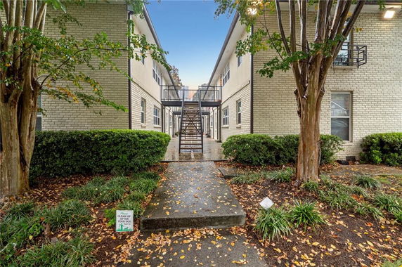 Front view of a two-story apartment building with exterior stairs.