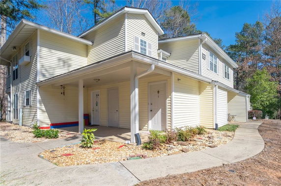 Front view of a two-story house with a covered entryway and multiple windows.
