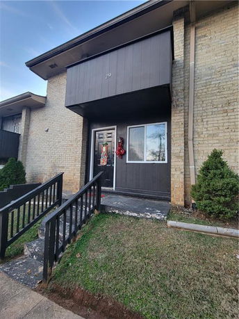 Front view of a house with a brick exterior and a black entrance door.