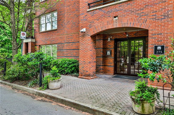 Front entrance of a brick building with arched doorway and pathway.