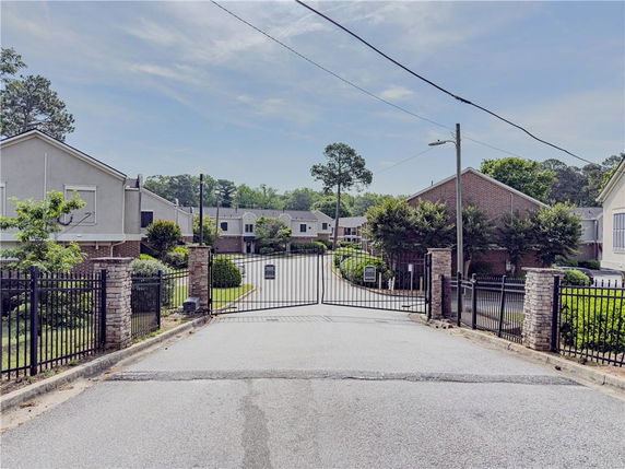 Front view of a gated residential complex with multiple buildings.