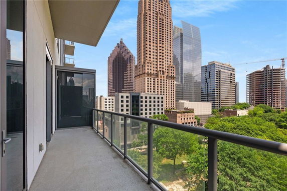 View from a balcony overlooking a cityscape with tall buildings.