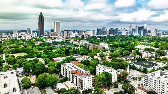 Wide angle view of an urban cityscape with tall buildings and greenery.