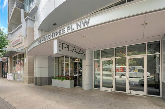 Front view of a commercial building entrance with large glass doors and signage.