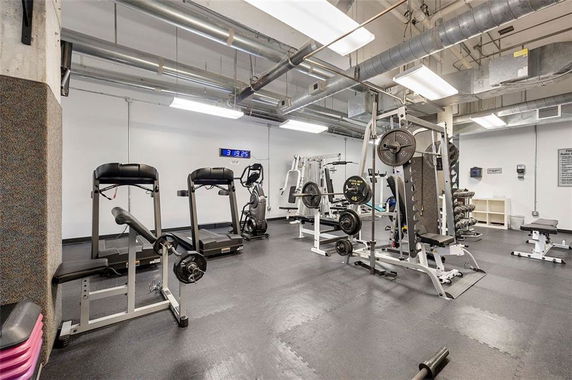Indoor gym area with various exercise equipment and fitness machines.