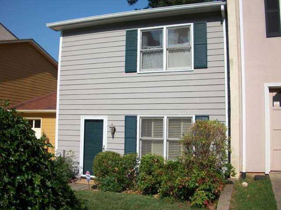 Front view of a two-story house with blue shutters and a single entrance.