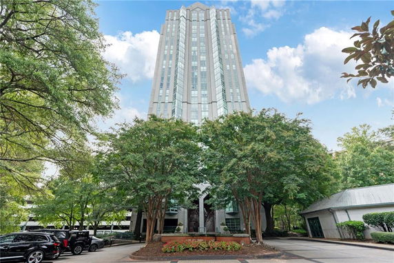 Front view of a tall multi-story building with a modern facade and large glass windows.