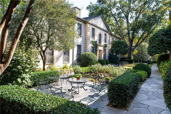Front view of a two-story house with a classic facade and manicured garden.