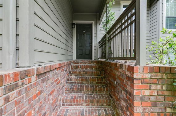 Front view of a house entrance with brick steps leading to a door.