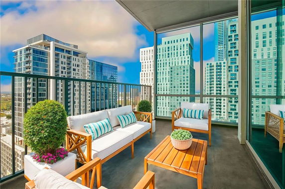 Balcony with outdoor furniture overlooking high-rise buildings.
