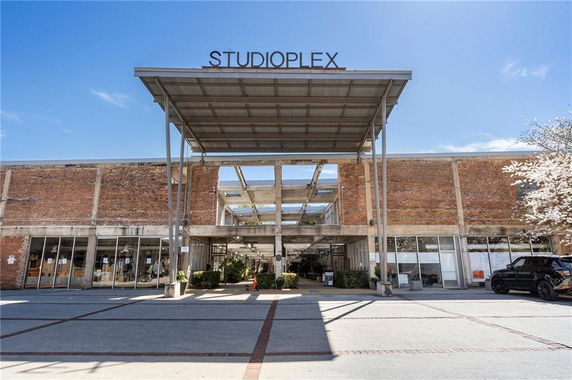 Front view of a commercial building with a metal canopy and glass doors.
