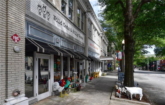 Front view of a multi-story building with awnings and storefronts.