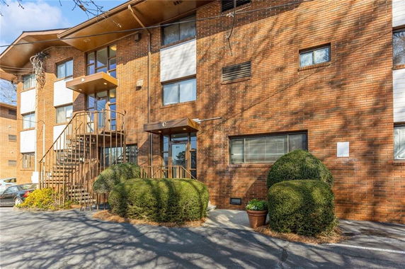 Front view of a multi-story brick apartment building with external staircases.