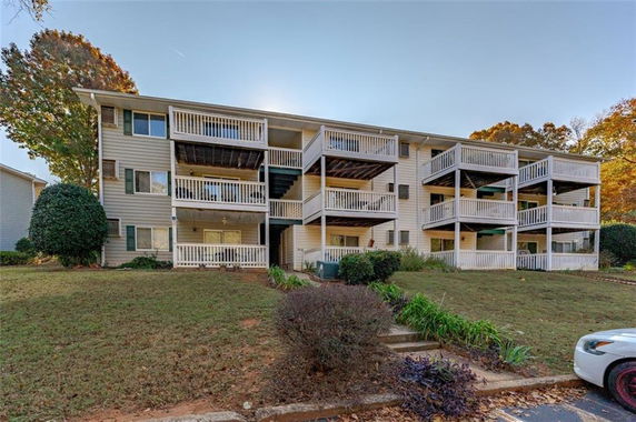 Front view of a three-story apartment building with balconies.