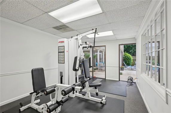 Indoor gym area with exercise equipment and a view of the outdoor patio.