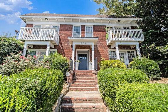 Front view of a two-story brick house with balconies.