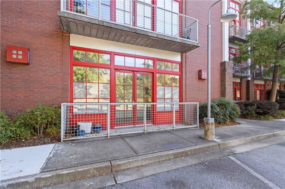 Front view of a modern building with brick facade and red-framed windows.