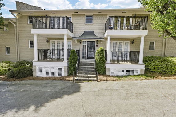 Front view of a two-story house with balconies and a central entrance.